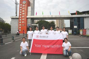 志愿者在万州田家炳学校校门前合照（2025年7月10日）刘昊天 摄